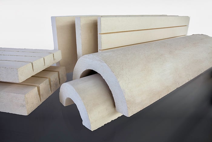 Tube-shaped and block-shaped pieces of a hard white substance, which is calcium silicate insulation